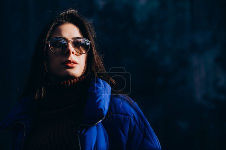 Téléchargez les photos : Jeune femme modèle en veste d'hiver bleue sur fond bleu - en image libre de droit