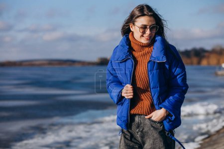 Téléchargez les photos : Jeune femme voyageuse veste bleue au bord du lac - en image libre de droit