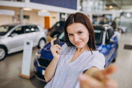Photo for Young woman in a car showroom choosing a car - Royalty Free Image