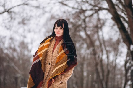 Foto de Joven mujer feliz en paños calientes en un parque de invierno - Imagen libre de derechos