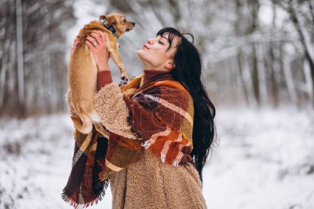 Photo for Young woman outside the park with her little dog at winter - Royalty Free Image