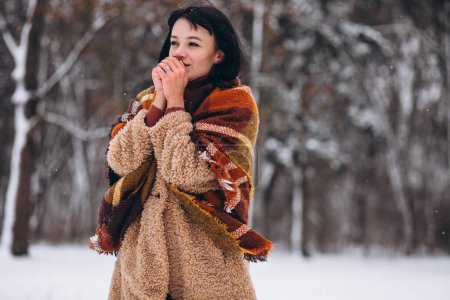 Téléchargez les photos : Jeune femme heureuse en chiffons chauds dans un parc d'hiver - en image libre de droit