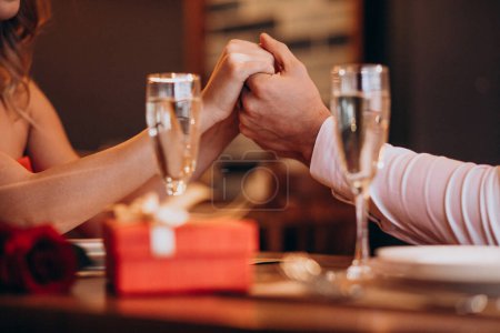 Téléchargez les photos : Couple se tenant la main le soir de la Saint-Valentin dans un restaurant - en image libre de droit