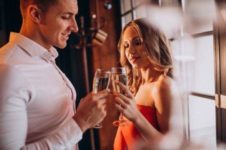 Photo for Couple drinking champaigne at a restaurant on valentines day - Royalty Free Image