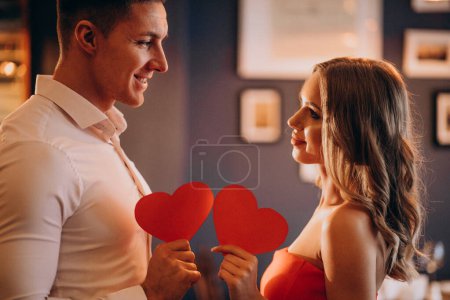 Photo for Couple holding paper hearts on valentines day - Royalty Free Image