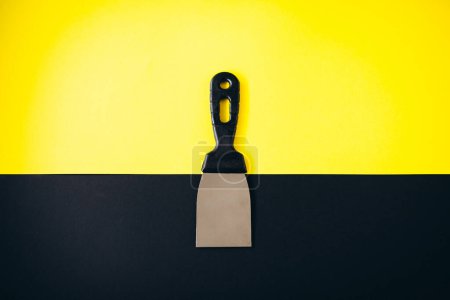 Téléchargez les photos : Couteau à mastic isolé sur fond noir et jaune - en image libre de droit