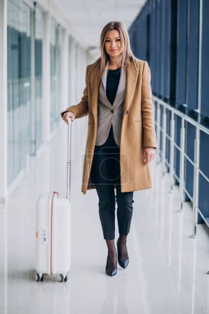 Téléchargez les photos : Femme d'affaires avec sac de voyage à l'aéroport - en image libre de droit