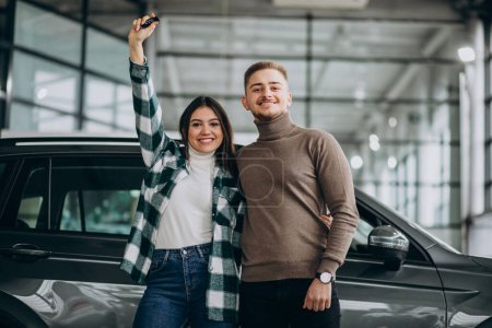 Photo for Young couple choosing a car in a car show room - Royalty Free Image