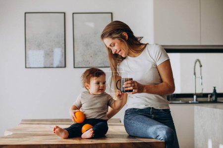 Photo for Young mother with little son drinking water at home - Royalty Free Image