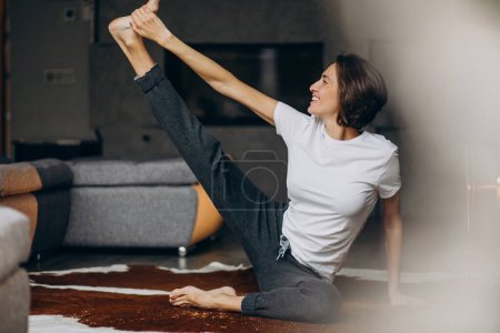 Photo for Young woman practicing yoga at home - Royalty Free Image