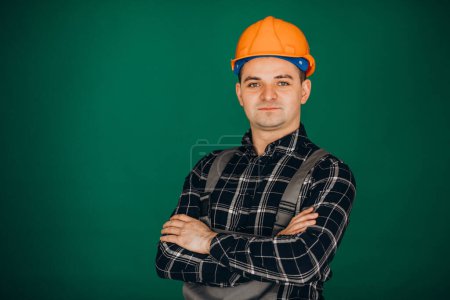 Téléchargez les photos : Homme travailleur en casque dur isolé sur fond vert - en image libre de droit