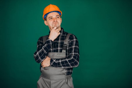 Photo for Man worker in hard hat isolated on green background - Royalty Free Image