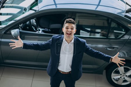Téléchargez les photos : Jeune homme d'affaires beau dans un showrrom de voiture - en image libre de droit