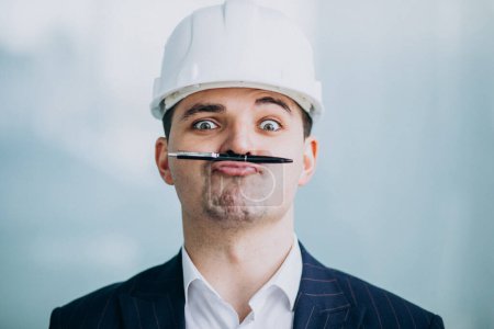 Téléchargez les photos : Bel homme d'affaires ingénieur en casque dur dans un bâtiment - en image libre de droit