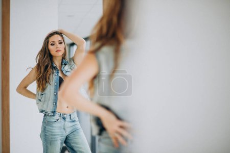 Téléchargez les photos : Jeune femme sexy st à la maison en tenue denim - en image libre de droit