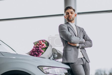 Photo for Young handsome business man delivering bouquet of beautiful flowers - Royalty Free Image