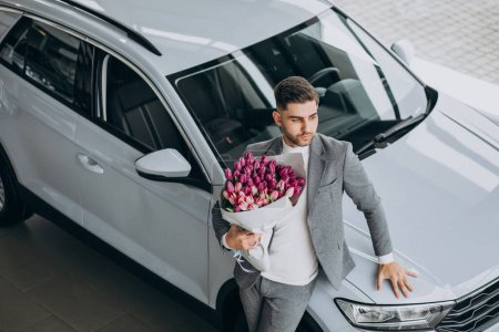 Foto de Joven hombre de negocios guapo entrega ramo de hermosas flores - Imagen libre de derechos