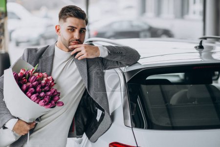 Téléchargez les photos : Jeune homme d'affaires beau livrer bouquet de belles fleurs - en image libre de droit