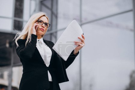 Photo for Middle aged business woman holding documents by the business center - Royalty Free Image