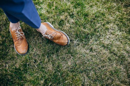 Téléchargez les photos : Jambes féminines portant des chaussures de près et debout sur l'herbe - en image libre de droit