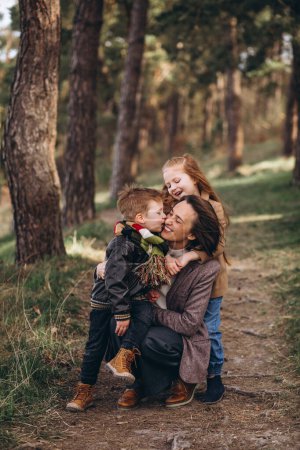 Foto de Joven madre con hija e hijo en el bosque - Imagen libre de derechos