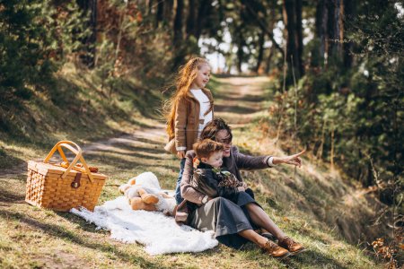 Foto de Madre con niños haciendo picnic en el bosque - Imagen libre de derechos