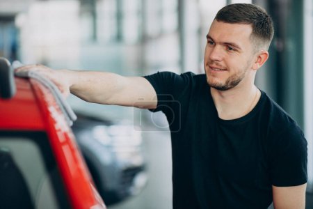 Photo for Young man polishing his car with rag - Royalty Free Image
