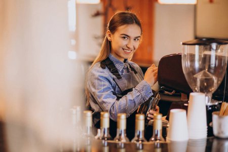 Photo for Female barista making coffee in a coffee machine - Royalty Free Image