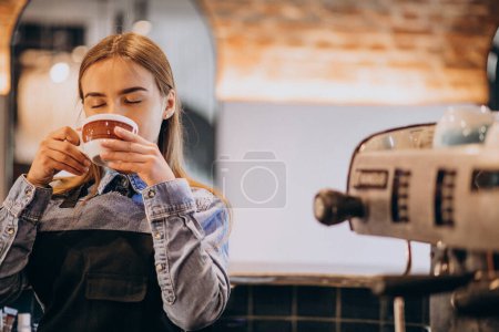 Photo for Female barista drinking coffee in a coffee shop - Royalty Free Image