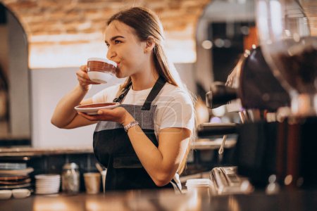 Photo for Female barista drinking coffee in a coffee shop - Royalty Free Image