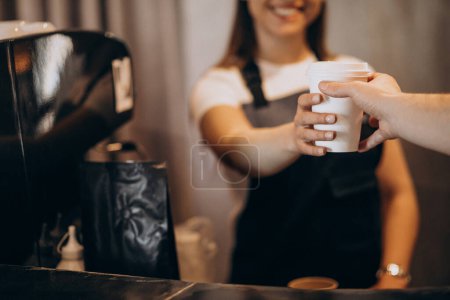 Téléchargez les photos : Female barista giving coffee to the customer - en image libre de droit