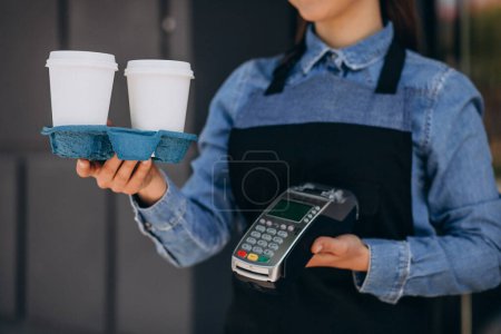 Téléchargez les photos : Female barista giving coffee in cardboard cups - en image libre de droit