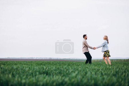 Téléchargez les photos : Jeune couple dans le champ avec herbe verte - en image libre de droit