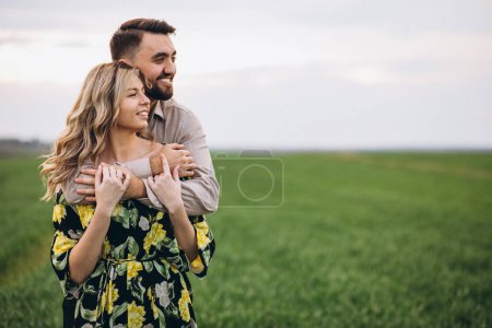 Téléchargez les photos : Jeune couple dans le champ avec herbe verte - en image libre de droit