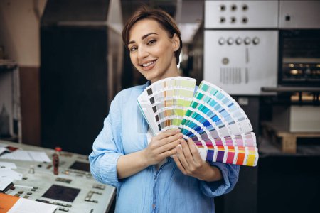 Foto de Mujer trabajando en imprenta sosteniendo paleta de muestras - Imagen libre de derechos