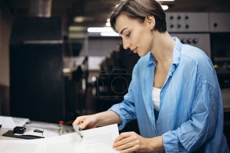 Foto de Mujer tipógrafa midiendo espesor de papel en imprenta - Imagen libre de derechos