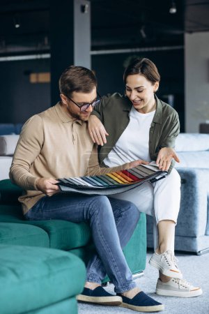 Photo for Woman and man looking at textile swatch in furniture store - Royalty Free Image