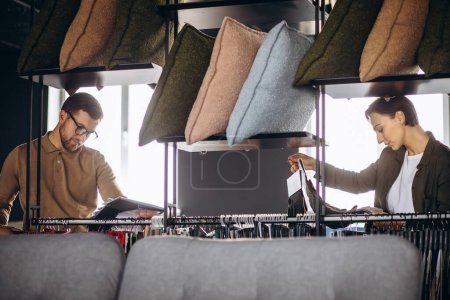 Foto de Mujer y hombre mirando la muestra textil en la tienda de muebles - Imagen libre de derechos