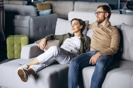 Photo for Couple choosing sofa and pillows at furniture store - Royalty Free Image