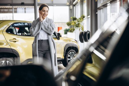Téléchargez les photos : Femme d'affaires choisissant une voiture dans une salle d'exposition de voiture - en image libre de droit