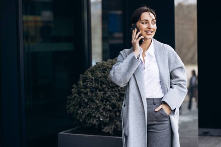 Photo for Business woman talking on the phone outside office bulding - Royalty Free Image