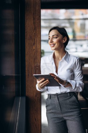 Foto de Mujer de negocios sosteniendo la tableta en un café - Imagen libre de derechos
