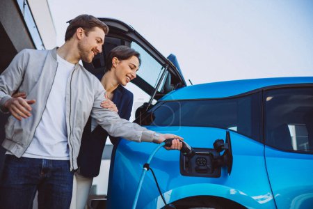 Téléchargez les photos : Couple recharge leur nouvelle voiture électrique - en image libre de droit