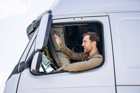 Téléchargez les photos : Chauffeur de camion assis dans la cabine de son camion - en image libre de droit