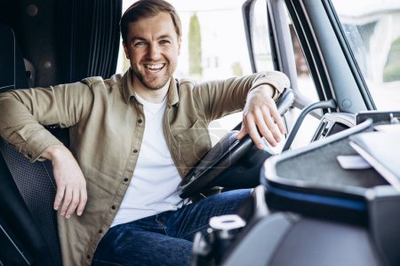 Téléchargez les photos : Chauffeur de camion assis dans la cabine de son camion - en image libre de droit