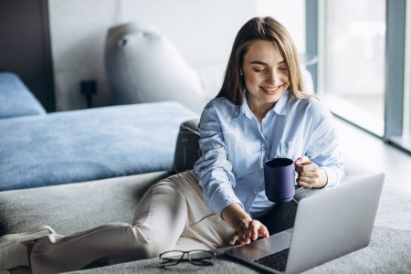 Téléchargez les photos : Femme d'affaires travaillant sur ordinateur portable et boire du café - en image libre de droit