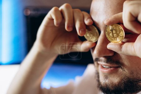 Photo for Man trader holding cryptocurrancy coins by his eyes - Royalty Free Image
