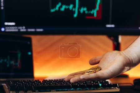 Téléchargez les photos : Main masculine avec crypto-monnaie avec marché des échanges informatiques sur fond - en image libre de droit