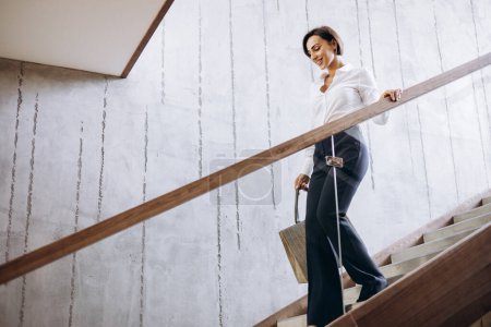 Foto de Mujer de negocios caminando las escaleras del hotel a su habitación - Imagen libre de derechos