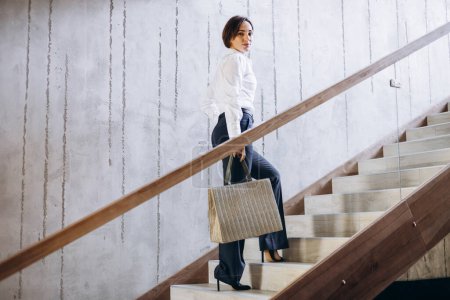 Téléchargez les photos : Femme d'affaires marchant les escaliers de l'hôtel à sa chambre - en image libre de droit